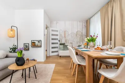 a living room with a dining table and a couch at Vistula Suite l A Lovely Place to Be in Kraków