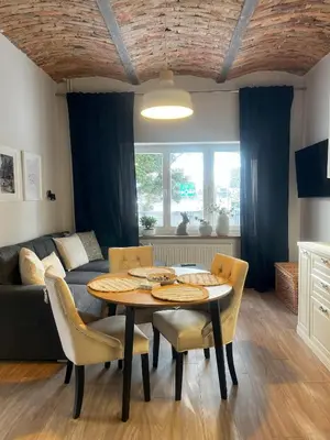 a living room with a table and chairs and a couch at Villa la Olive Premium Apartaments-Luxury Standard in Oświęcim