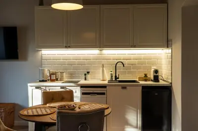a kitchen with a table and a sink and a counter at Villa la Olive Premium Apartaments-Luxury Standard in Oświęcim