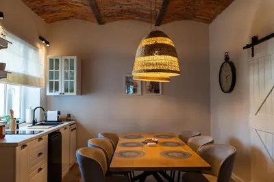 a kitchen with a wooden table with chairs and aendant light at Villa la Olive Premium Apartaments-Luxury Standard in Oświęcim