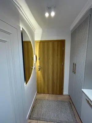 a hallway with a wooden door and a rug at Krakow Center Stare Podgorze in Kraków