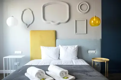 a bedroom with a bed with towels and mirrors at Golden Apartments Krakow Old Town in Kraków