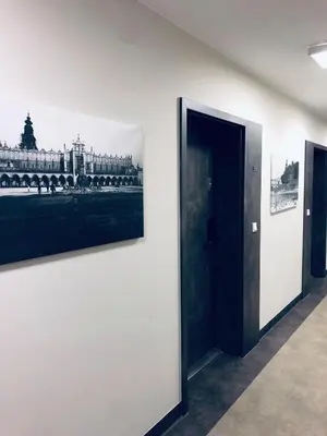 a hallway with two paintings on the wall and a doorway at Golden Apartments Krakow Old Town in Kraków