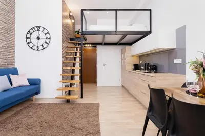 a kitchen and a living room with a blue couch at Nowoczesny Apartament w Centrum Krakowa by Noclegi Renters in Kraków
