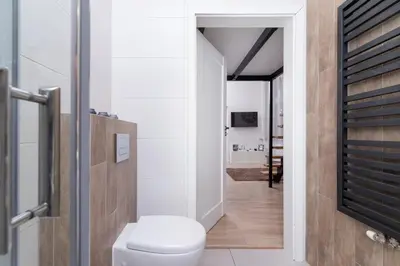 a bathroom with a toilet and a walk in shower at Nowoczesny Apartament w Centrum Krakowa by Noclegi Renters in Kraków