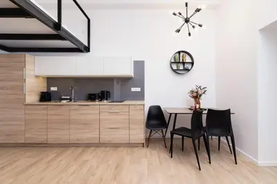 a kitchen and dining room with a table and chairs at Nowoczesny Apartament w Centrum Krakowa by Noclegi Renters in Kraków