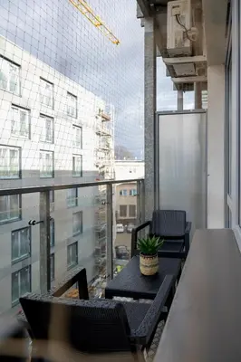 a balcony with a table and chairs and a large window at Turquoise Studio with Balcony & Air Conditioning Kraków by Noclegi Renters in Kraków