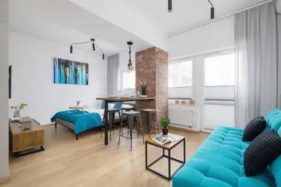 a living room with a blue couch and a table at Turquoise Studio with Balcony & Air Conditioning Kraków by Noclegi Renters in Kraków