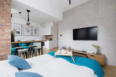 a bedroom with a bed and a living room at Turquoise Studio with Balcony & Air Conditioning Kraków by Noclegi Renters in Kraków