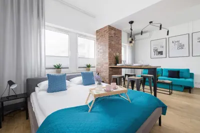a living room with a bed and a dining room at Turquoise Studio with Balcony & Air Conditioning Kraków by Noclegi Renters in Kraków