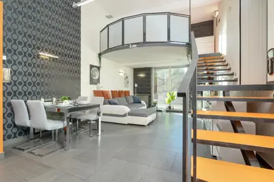 a living room with a couch and a table and a staircase at Apartament Przyszłości z dwiema sypialniami w Krakowie by Noclegi Renters in Kraków