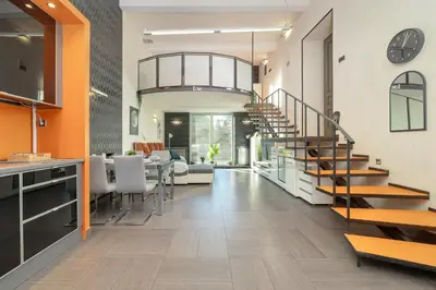 a living room with a staircase and a dining room at Apartament Przyszłości z dwiema sypialniami w Krakowie by Noclegi Renters in Kraków