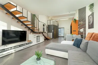 a living room with a couch and a large tv at Apartament Przyszłości z dwiema sypialniami w Krakowie by Noclegi Renters in Kraków