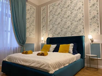 a bedroom with a blue bed with yellow pillows on it at Radiance Residence Apartments in Kraków