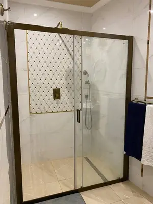 a shower with a glass door in a bathroom at Radiance Residence Apartments in Kraków