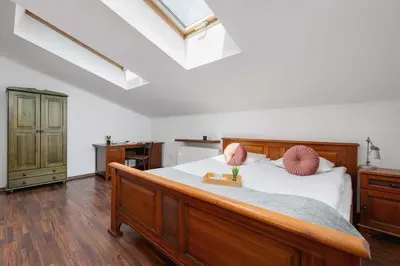 a bedroom with a large wooden bed with pink pillows at Asnyka Wyjątkowy Apartament w Centrum Krakowa by Noclegi Renters in Kraków
