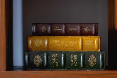 a stack of books sitting on a shelf at Asnyka Wyjątkowy Apartament w Centrum Krakowa by Noclegi Renters in Kraków