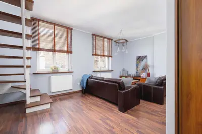a living room with a couch and a staircase at Asnyka Wyjątkowy Apartament w Centrum Krakowa by Noclegi Renters in Kraków