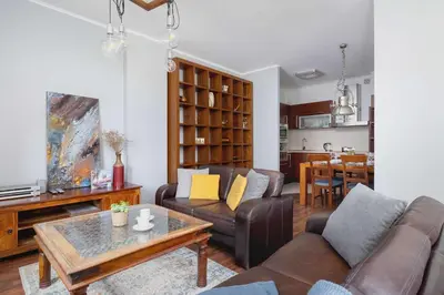 a living room with a couch and a table at Asnyka Wyjątkowy Apartament w Centrum Krakowa by Noclegi Renters in Kraków