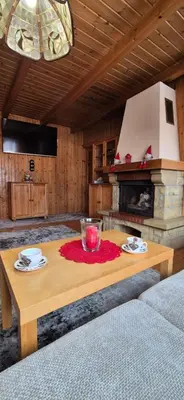 a living room with a table and a fireplace at SOWIA CHATKA- Stryszawa - domek z jacuzzi in Stryszawa