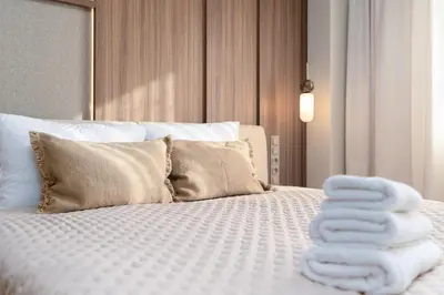 a bed with a pile of towels on it at Cracow Superior Apartment by BookingHost in Kraków