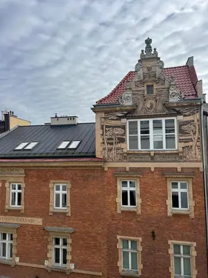 a red brick building with a black roof at Cracow Superior Apartment by BookingHost in Kraków