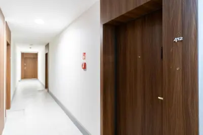 an empty corridor with a wooden door in a building at Cracow Superior Apartment by BookingHost in Kraków