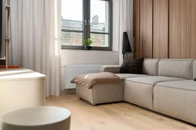 a living room with a couch and a chair at Cracow Superior Apartment by BookingHost in Kraków