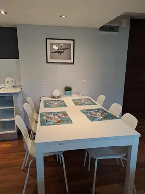 a dining room table with white chairs around it at DaVinci Bello apartment in Kraków