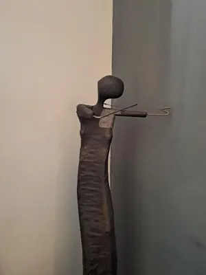 a sculpture of a dress with a chair on a wall at DaVinci Bello apartment in Kraków