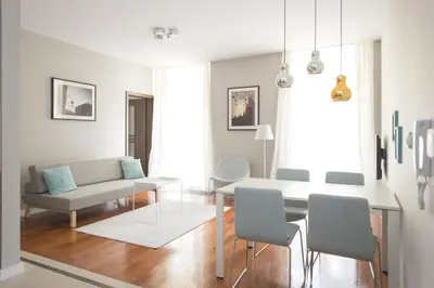 a living room with a couch and a table and chairs at Pastel Apartment in Kraków