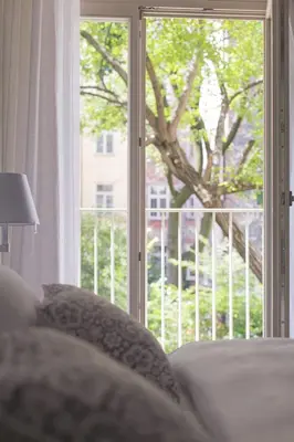 a living room with a window with a view of a tree at Pastel Apartment in Kraków