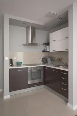 a kitchen with brown cabinets and a stove at Pastel Apartment in Kraków