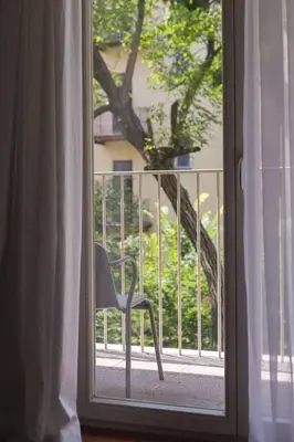 a window with a chair sitting on a balcony at Pastel Apartment in Kraków