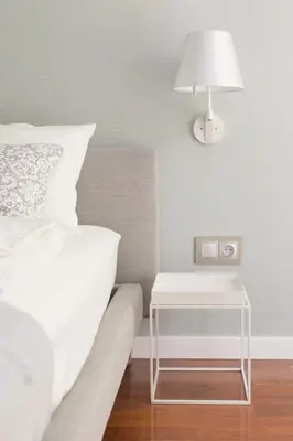 a bedroom with a bed and a table with a lamp at Pastel Apartment in Kraków