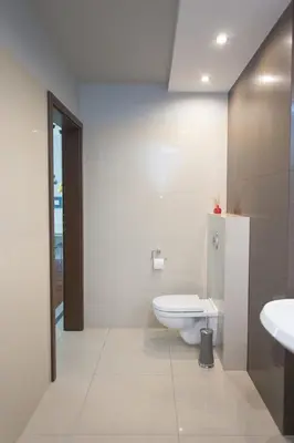 a white bathroom with a toilet and a sink at Pastel Apartment in Kraków