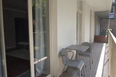 a balcony with a table and chairs next to a building at Pastel Apartment in Kraków