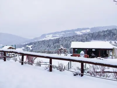 a playground covered in snow next to a building at Agroturystyka Faron in Rozdziele