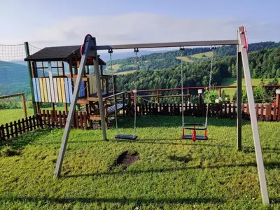 a view of a playground with mountains in the background at Agroturystyka Faron in Rozdziele