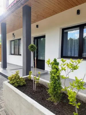 a house with plants in front of it at Domek za rzeką 2 in Zawoja