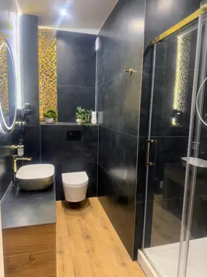 a bathroom with a toilet and a glass shower at Domek za rzeką 2 in Zawoja