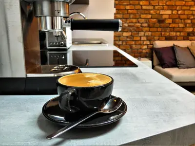a cup of coffee on a counter with a spoon at Old Town Apt -Bosacka 2 bedrooms B43 in Kraków