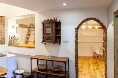 a kitchen with an archway and a table in a room at Apartment no5 Szlak street in Kraków