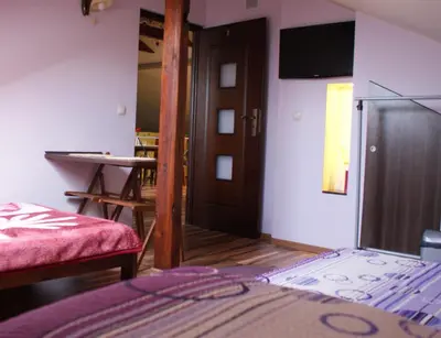 a bedroom with a bed and a door and a table at Noclegi Weronika in Czajowice