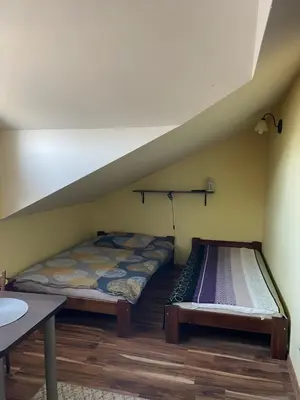 a room with two beds in a room with a staircase at Noclegi Weronika in Czajowice
