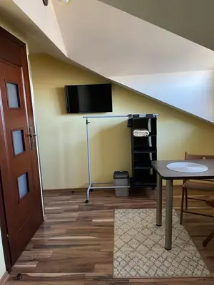 a room with a table and a tv on the wall at Noclegi Weronika in Czajowice
