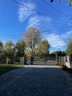 a gate in a park with a brick driveway at Noclegi Weronika in Czajowice