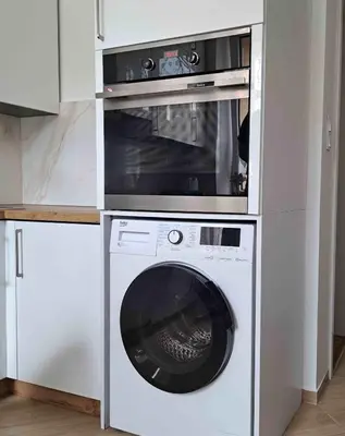 a washer and dryer in a white kitchen at Apartament Słowackiego in Oświęcim