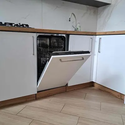 a kitchen with white cabinets and a dishwasher at Apartament Słowackiego in Oświęcim