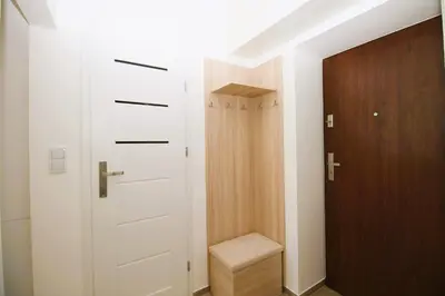 a closet with a door and a stool in a room at Apartament Słowackiego in Oświęcim
